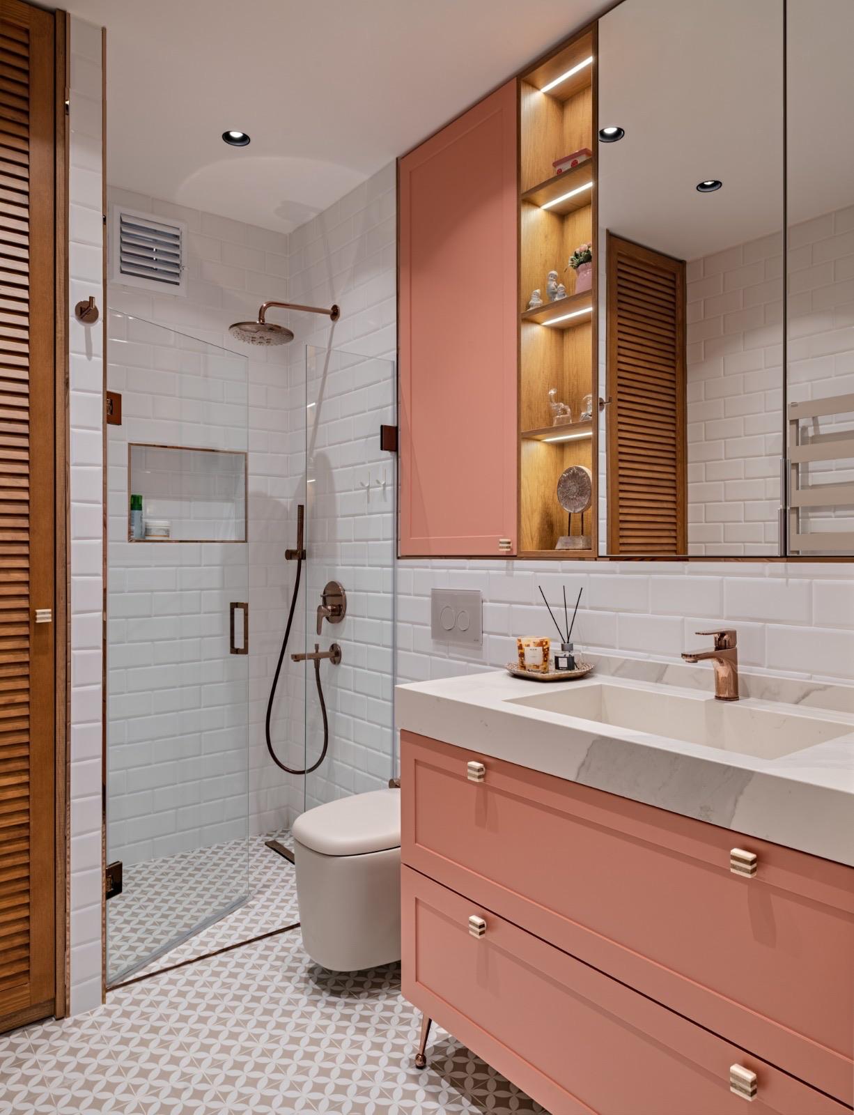 Mercan tonlu duvarlar ve ahşap nişlerle tasarlanan banyo